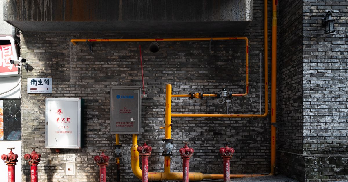 Red fire hydrant and pipework in an industrial area